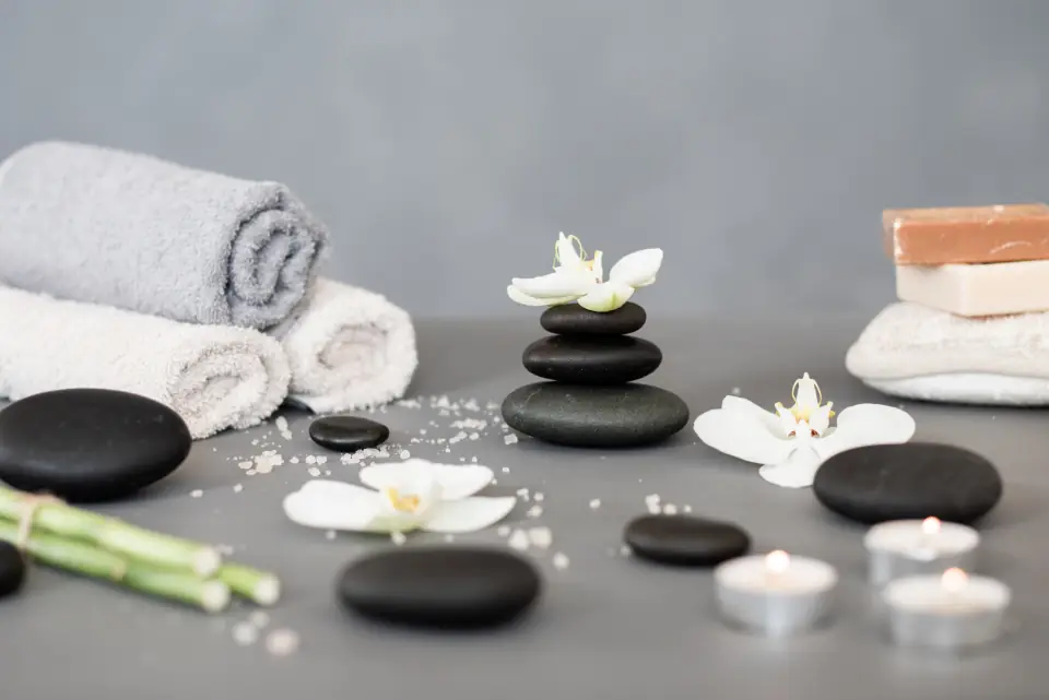 Toallas, piedras y orquídeas sobre una mesa