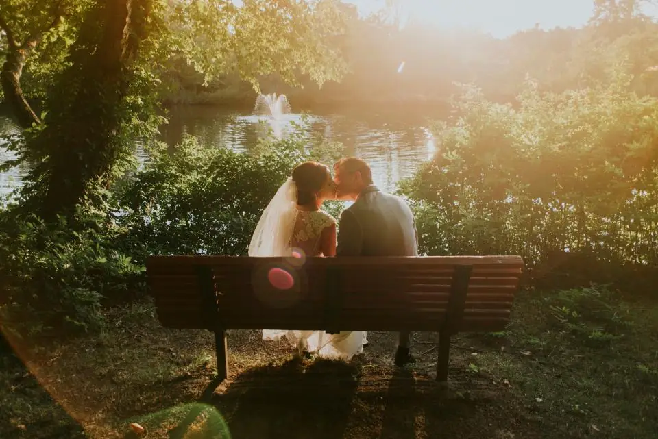 Novios besándose en una banca del parque