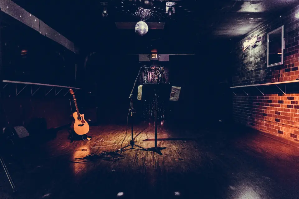 Escenario vacío con una guitarra y micrófono