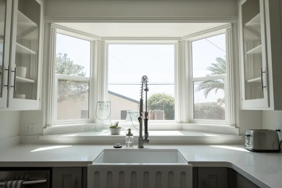 Cocina con ventana amplia y mesón blanco