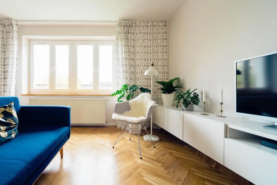 Sala luminosa con sofá azul y piso de madera