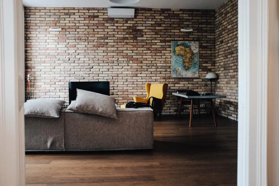Loft con pared de ladrillo y sala gris