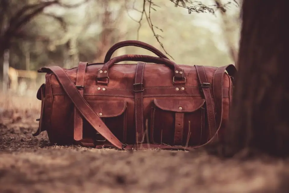 Bolso de cuero café sobre la hierba
